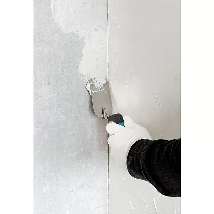 Alpha Tools Kellen-Set - 3 -tlg. - Behandschuhte Hand glättet weißen Putz mit einer Metallspachtel an einer Wand.