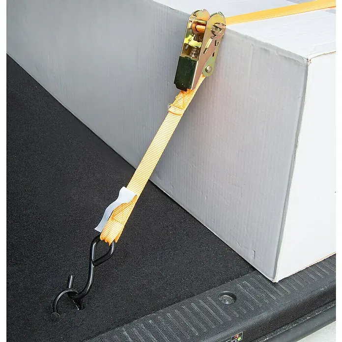 Ladungssicherungs-Set - 8 -tlg. - Ein gelber Spanngurt mit Ratsche sichert eine weiße Kiste im Laderaum, um ein Verrutschen während des Transports zu verhindern.