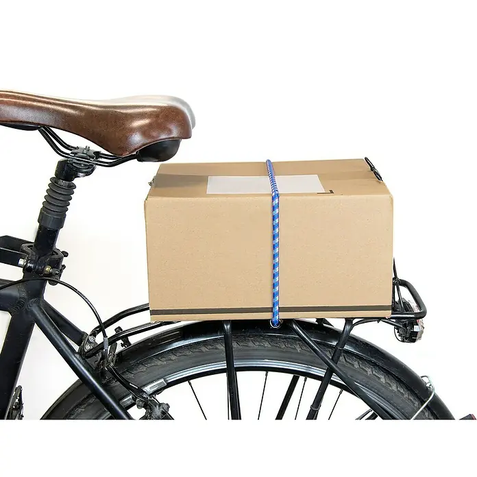 Ladungssicherungs-Set - 8 -tlg. - Ein Fahrrad mit einem braunen Sattel und einem Karton, der mit einem blauen Gummiband auf dem Gepäckträger befestigt ist.