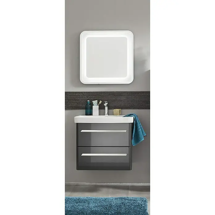 Badmöbel-Set MO60G2 - Gesamtbreite Badmöbel: 60 cm, Grafit, Hochglänzend, 3 -tlg. - Das Bild zeigt einen modernen Waschtisch mit grauem Unterschrank, weißem Waschbecken und beleuchtetem Spiegel vor einer grauen Wand. Ein blauer Teppich liegt davor.