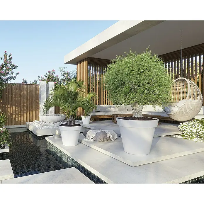 Artevasi Capri Pflanztopf - Außenmaß (Ø x H): 25 x 21,5 cm, Kunststoff, Weiß - Diese Aufnahme zeigt einen Garten mit großen, weißen Pflanzgefäßen und üppiger Vegetation, die eine ruhige Atmosphäre schaffen.