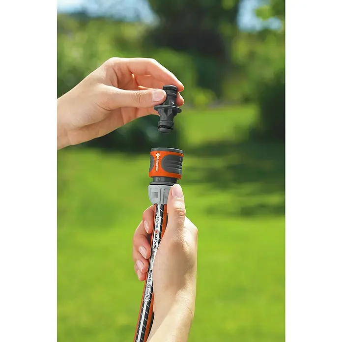 Gardena Schlauchkupplung - Grau - Eine Person verbindet ein Gardena-Gartenschlauchstück. Das Original Gardena System sorgt für eine wasserdichte Verbindung.