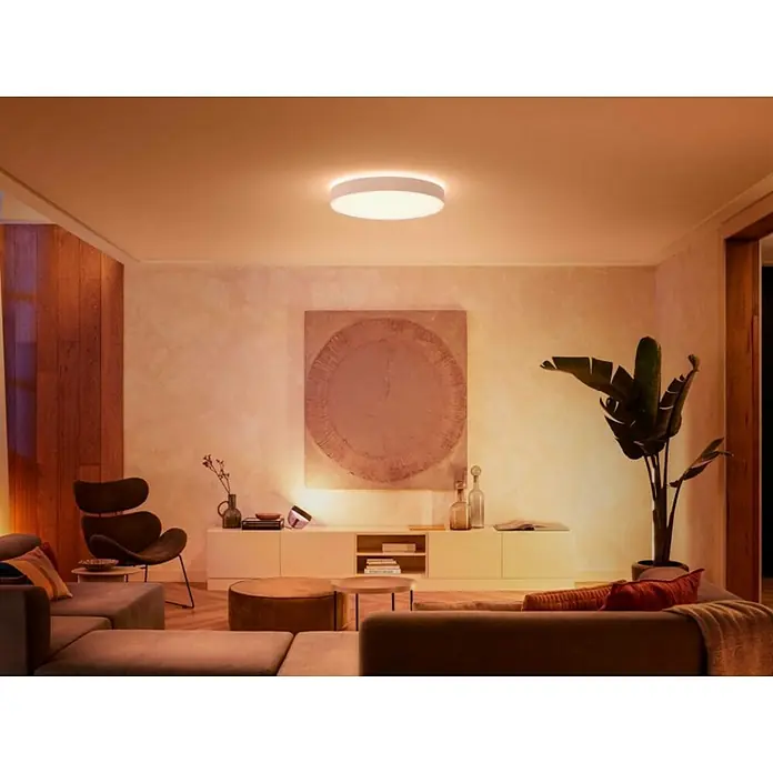 Philips Hue LED-Deckenleuchte rund White Ambience Enrave XL - 48 W, Ø x H: 55,1 x 8,4 cm, Weiß, Kaltweiß - Ein modernes Wohnzimmer mit einer runden Deckenleuchte, die ein warmes, einladendes Licht verbreitet. Die Lampe ist schlicht und elegant.