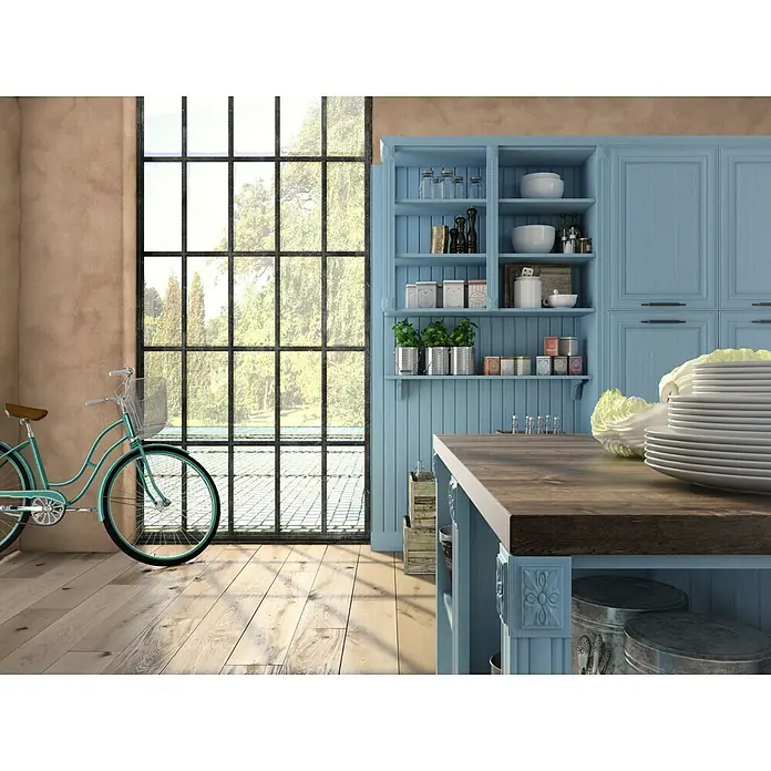 Osaka Yeso con efecto de color CalDur - Beige, Mate - Cocina luminosa con platos en una encimera, una ventana panorámica y una bicicleta azul apoyada contra la pared.