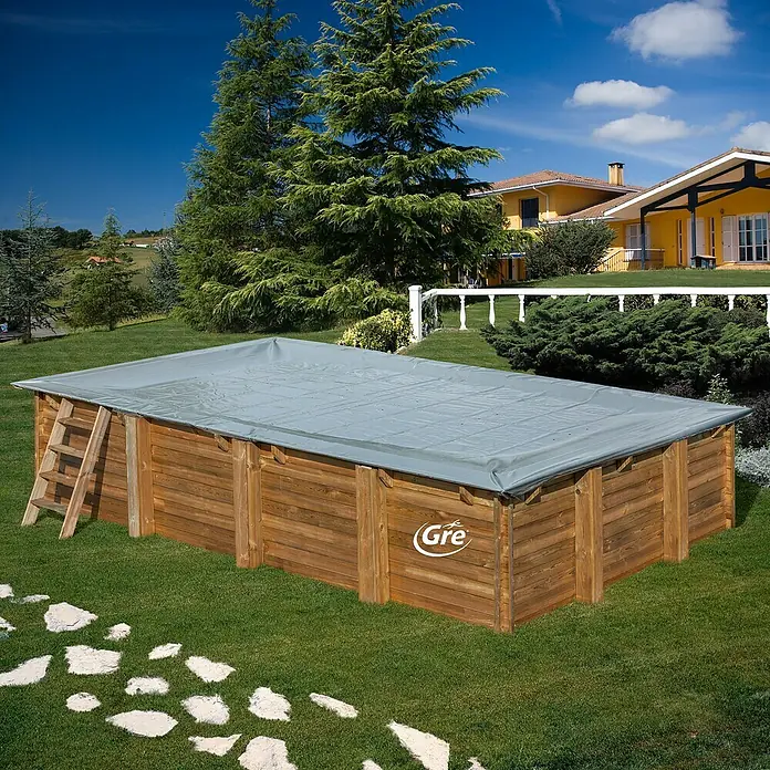 Gre Pool-Abdeckplane Winter - L x B: 658 x 360 cm, Kunststoff - Ein rechteckiger Gre-Holzpool mit Abdeckung und Leiter im Garten, umgeben von Bäumen und einem Haus im Hintergrund.