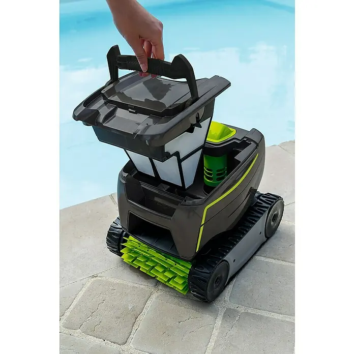 Zodiac Robot de piscina Tornax GT2120 - Funcionamiento en red, Piscinas 8 x 4 m, 11 m³/h - Un robot de limpieza de piscinas gris con un accesorio de cepillo verde y un compartimento de filtro abierto es sostenido por una mano.