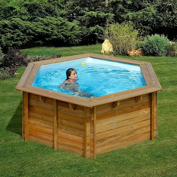 Gre Piscina de madera Lili 2 - Ø x Al: 280 x 107 cm, Marrón, 4.500 l - Piscina de madera en el jardín con un niño jugando. El diseño de madera natural se integra perfectamente con el entorno verde.