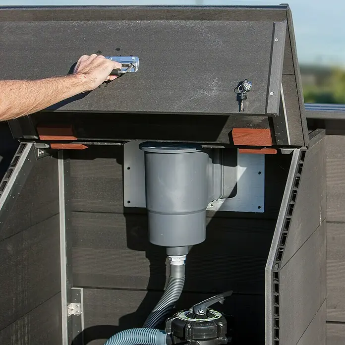 Gre Technikraum für Kompositpools - L x B x H: 80 x 60 x 89 cm, WPC - Eine graue Poolpumpe in einem dunklen, wetterfesten Schrank mit geöffneter Klappe, die Wartungsfreundlichkeit und Schutz bietet.
