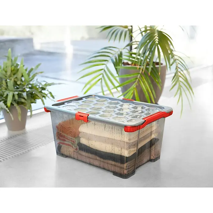 Rotho Aufbewahrungsbox Evo Total - L x B x H: 59 x 39,5 x 28 cm, Fassungsvermögen: 44 l, Kunststoff, Farbe Deckel: Transparent - Transparente Aufbewahrungsbox mit rotem Verschluss gefüllt mit Kleidung. Praktische Aufbewahrungslösung für Kleidung oder andere Gegenstände.