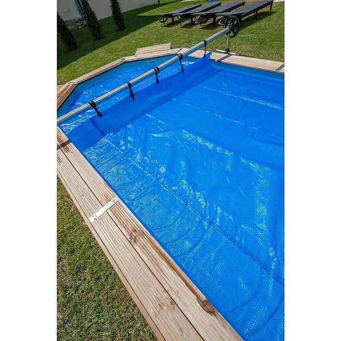Gre Planenaufroller - Passend für: Pools bis 500 cm Breite - Schwimmbad mit blauer Poolabdeckung aufgerollt, um das Wasser warm zu halten und Schmutz fernzuhalten. Die Abdeckung ist auf einer Aufrollvorrichtung montiert.