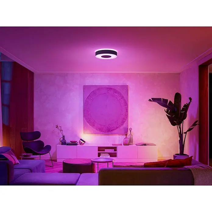 Philips Hue LED-Deckenleuchte rund White and color ambience Infuse M - Ø x H: 38,1 x 8,4 cm, RGBW - Moderne Deckenleuchte in einem Wohnzimmer mit lila Ambientebeleuchtung. Das Lichtdesign setzt einen eleganten Akzent.