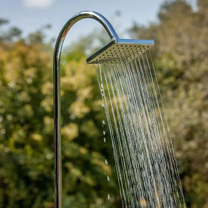 Gre Ducha solar Esencial Deluxe - Altura: 223 cm, Aluminio, Antracita - Primer plano de una ducha exterior cromada con agua fluyendo, sobre un fondo verde borroso.