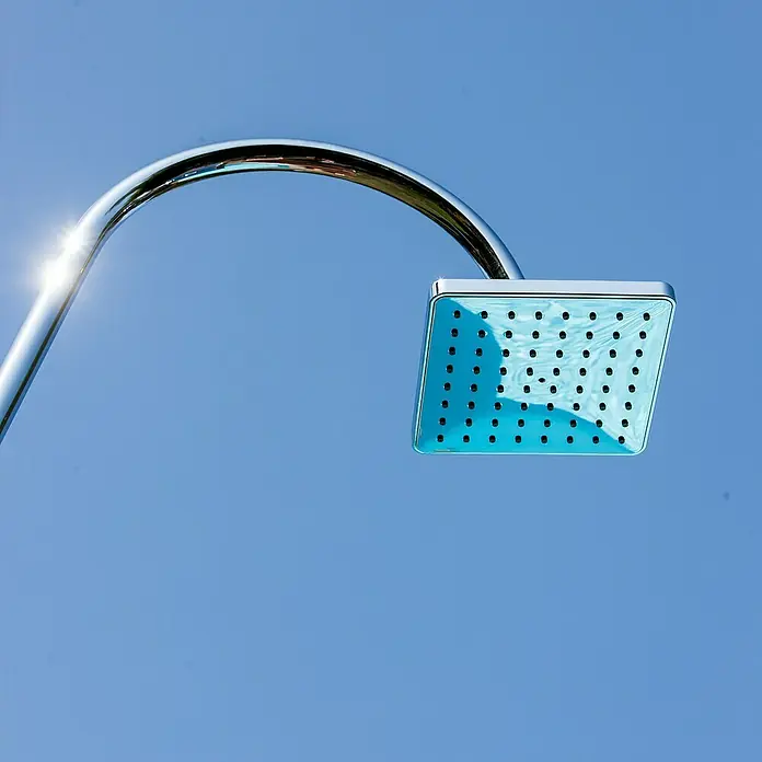 Gre Ducha solar Esencial Deluxe - Altura: 223 cm, Aluminio, Antracita - Moderna alcachofa de ducha cuadrada cromada contra un cielo azul. Superficie brillante que refleja la luz solar. Accesorio de baño elegante.
