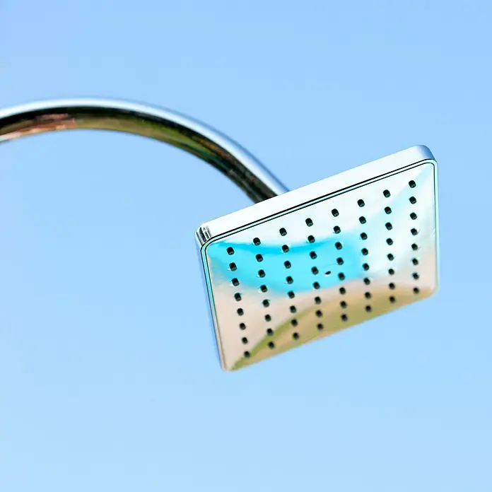 Gre Ducha solar Esencial Deluxe - Altura: 223 cm, Aluminio, Antracita - Primer plano de un moderno cabezal de ducha cromado cuadrado contra un cielo azul.