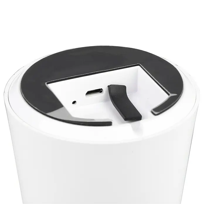 Trio Leuchten Akku-Tischleuchte Lennon - 2 W, Weiß, Warmweiß - Nahaufnahme eines weißen, zylindrischen Geräts mit schwarzer Oberseite, das einen USB-Anschluss und eine Öffnung zeigt.