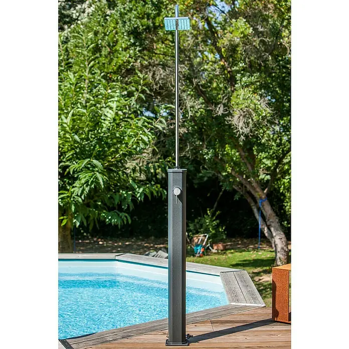 Gre Ducha solar Esencial Deluxe - Altura: 223 cm, Aluminio, Antracita - Ducha exterior de metal oscuro con cabezal cuadrado junto a una piscina en una terraza de madera.