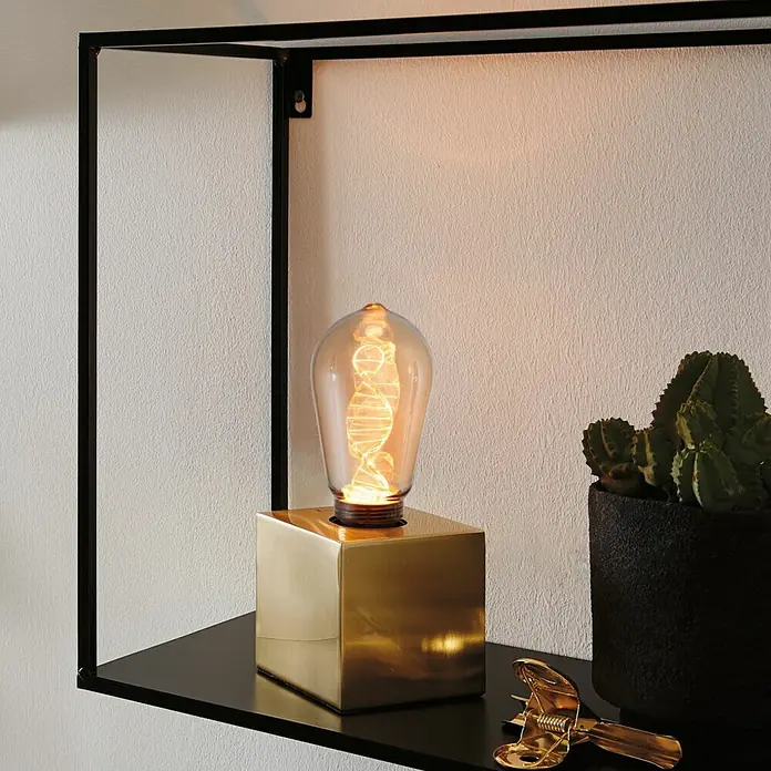 Paulmann Inner Glow LED-Lampe Vintage Glühlampenform E27 - E27, Nicht Dimmbar, Gelb, 180 lm, 3,5 W, Tropfen, Farbe: Gold - Nahaufnahme einer dekorativen Glühbirne mit goldenem Sockel auf einem schwarzen Regal, neben einem Kaktus und einem goldenen Clip.
