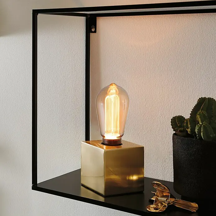Paulmann Inner Glow LED-Lampe Vintage Glühlampenform E27 - E27, Nicht Dimmbar, Gelb, 160 lm, 3,5 W, Tropfen, Farbe: Gold - Nahaufnahme einer dekorativen Edison-Glühbirne mit goldenem Sockel auf einem Regal, die ein warmes Licht ausstrahlt.