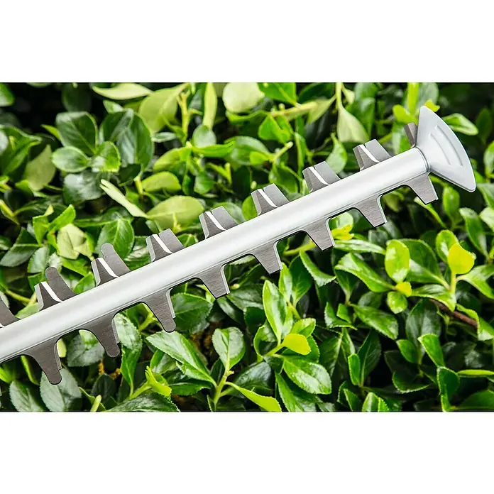 Bosch Elektro-Heckenschere AdvancedHedgeCut 70 - 500 W, Schnittlänge: 70 cm - Nahaufnahme der Klingen einer Heckenschere vor einem Hintergrund aus üppigem Grün, wobei die Schärfe und Präzision des Werkzeugs hervorgehoben werden.