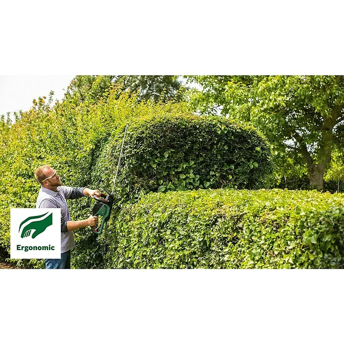 Bosch Elektro-Heckenschere AdvancedHedgeCut 70 - 500 W, Schnittlänge: 70 cm - Ein Mann schneidet mit einer Bosch Heckenschere eine Hecke, um sie zu formen. Ergonomisches Design für komfortable Nutzung.