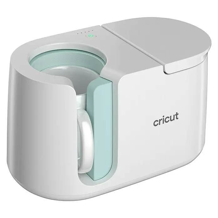 Cricut Transferpresse Mug Press - Passend für: Infusible Ink- und sublimationskompatible Tassenrohlinge - Nahaufnahme einer weißen Cricut Mug Press, einem Gerät zum Bedrucken von Tassen, mit einem mintgrünen Akzent und einer Tasse.