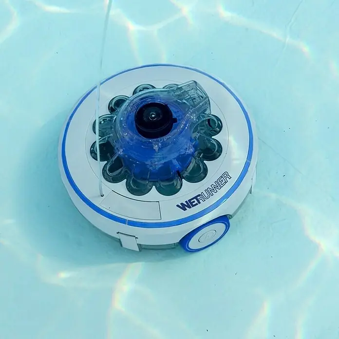Gre Robot de piscina a batería Wet Runner - A batería, Piscinas de hasta 7 x 5 m, 3,6 m³/h - Un robot de limpieza de piscinas WERUNNER blanco y azul está en el agua, limpiando la piscina.