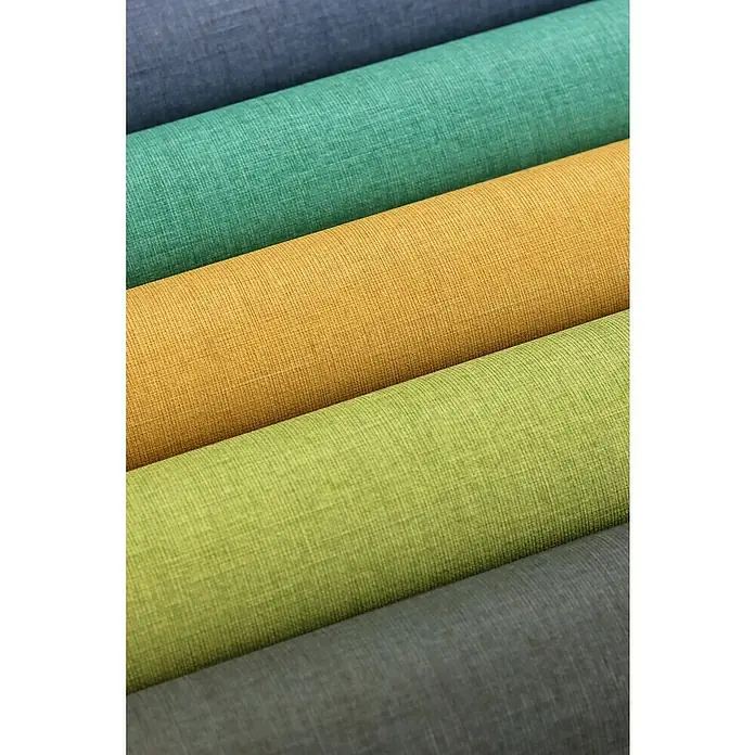 Rasch Florentine III Vliestapete - Dunkelblau, Uni, 10,05 x 0,53 m - Nahaufnahme von gerollten Stoffen in verschiedenen Farben, die eine interessante Textur und eine Palette von Blau, Grün, Gelb und Grau zeigen.