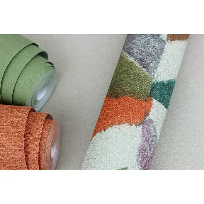 Rasch Salsa Vliestapete - Kaki, Uni, 10,05 x 0,53 m - Nahaufnahme von drei Tapetenrollen in Grün, Orange und mit abstraktem Muster, die Textur und Farben der Tapeten hervorheben.