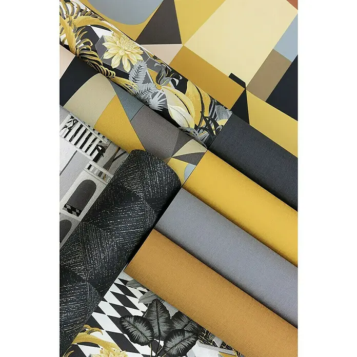 Rasch Tropical House Vliestapete - Schwarz, Uni, 10,05 x 0,53 m - Nahaufnahme von verschiedenen stilvollen Tapetenrollen mit geometrischen und floralen Mustern in Gelb-, Grau- und Schwarztönen.