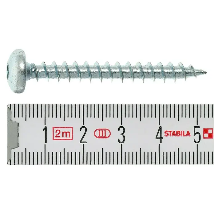 Profi Depot Spanplattenschraube VZ - 6 x 50 mm, 100 Stk., Verzinkt, TX für TORX-Antriebe - Eine Nahaufnahme einer Schraube, die mit einem Zollstock gemessen wird. Die Schraube ist silberfarben und liegt auf einem schwarzen Hintergrund.