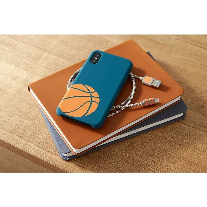 Cricut Joy Vinylfolie Smart Vinyl Permanent - Orange, 122 x 14 cm, Dauerhaft klebend - Handy mit Basketballhülle und Ladekabel, liegt auf zwei Notizbüchern. Tolle Kombination aus Schutz und praktischem Zubehör!