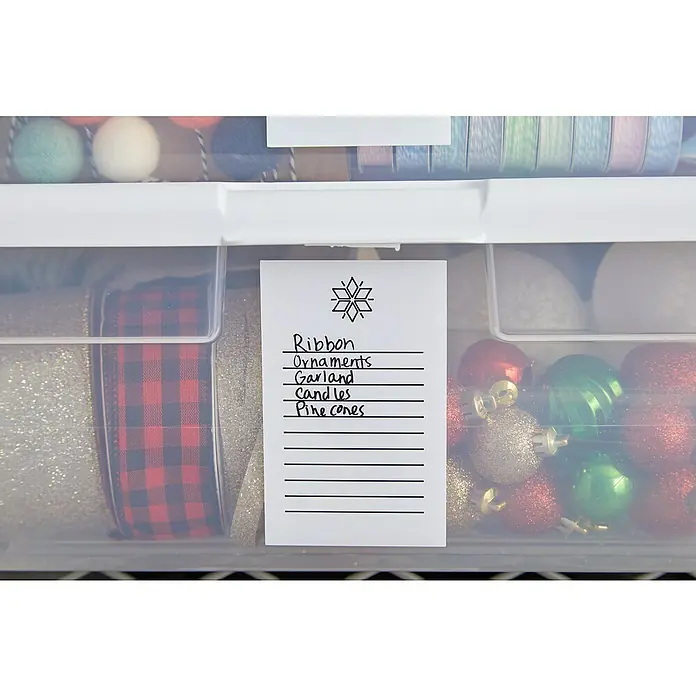 Cricut Joy Vinylfolie Smart Label - Weiß, 122 x 14 cm - Aufbewahrungsbox mit Weihnachtsdekoration wie Bänder, Ornamente, Girlanden, Kerzen und Tannenzapfen, beschriftet mit einer handgeschriebenen Notiz.