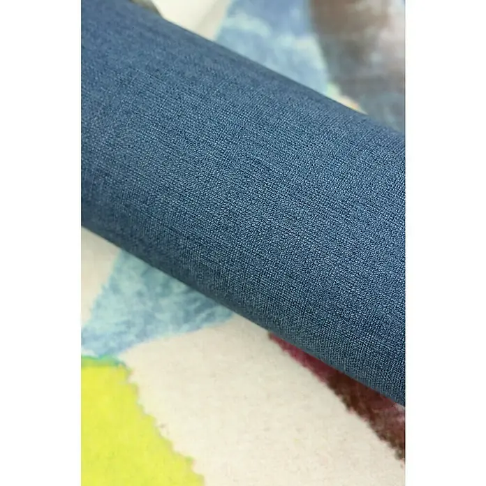 Rasch Salsa Vliestapete - Dunkelblau, Uni, 10,05 x 0,53 m - Nahaufnahme eines Rollens Stoff in einem satten Blauton, ideal für Polsterprojekte oder hochwertige Bekleidung. Die Textur verspricht Strapazierfähigkeit.
