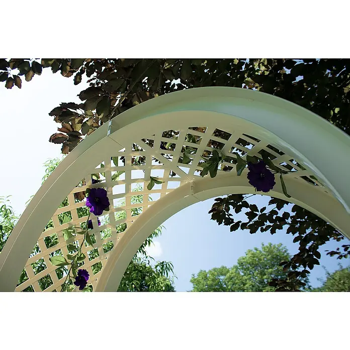 KHW Gartenbank Amsterdam - B x T x H: 174 x 49 x 207 cm, Weiß - Ein weißer Rosenbogen mit lila Blumen geschmückt, steht vor dem Hintergrund von Bäumen und blauem Himmel. Schafft eine romantische Atmosphäre für Hochzeiten.
