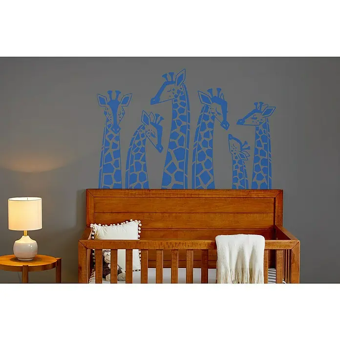 Cricut Maker Schneideplotter Maker 3 - Blau, Bluetooth, Schnittbreite: 29,7 cm, Schnittlänge: 3,6 m - Ein Kinderzimmer mit einer Wanddekoration mit blauen Giraffen über einem hölzernen Kinderbett und einer Nachttischlampe.