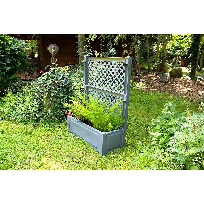 KHW Pflanzkasten - Außenmaß (L x B x H): 100 x 43 x 140 cm, Kunststoff, Grau - Ein graues Pflanzgefäß mit Rankgitter steht inmitten eines üppigen Gartens, bepflanzt mit üppigem Grün und roten Akzenten, die einen Blickfang bieten.