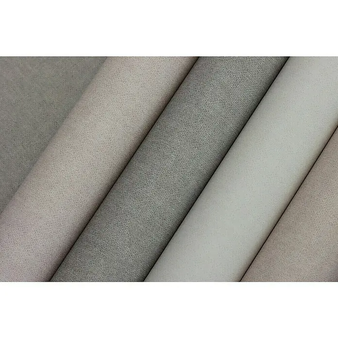 Rasch Bambino XIX Vliestapete - Creme, Uni, 10,05 x 0,53 m - Nahaufnahme von farblich sortierten Stoffrollen. Die Stoffrollen haben unterschiedliche Grautöne und liegen nebeneinander.