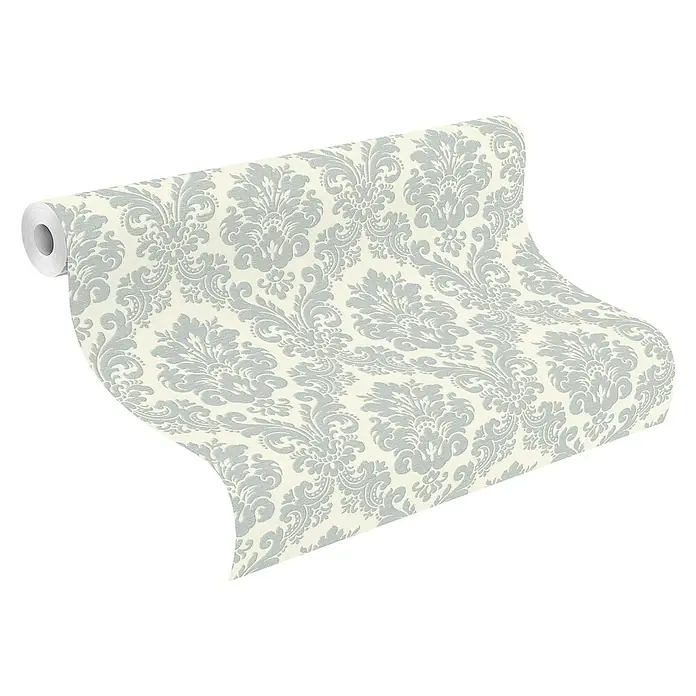 Rasch Trianon XIII Vliestapete Barock - Blau, Ornament, 10,05 x 0,53 m - Nahaufnahme einer Rolle stilvoller, cremefarbener Tapete mit einem eleganten, silbernen Damastmuster, perfekt für die gehobene Inneneinrichtung.