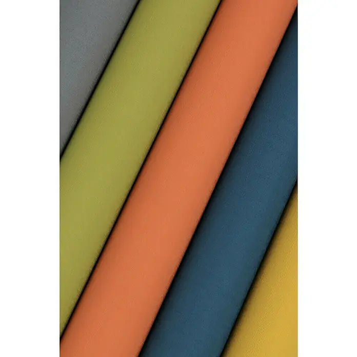 Rasch Tropical House Vliestapete - Dunkelblau, Uni, 10,05 x 0,53 m - Farbige Tapetenrollen liegen schräg nebeneinander und zeigen ihre Textur und Farbvielfalt, perfekt für die Inneneinrichtung.