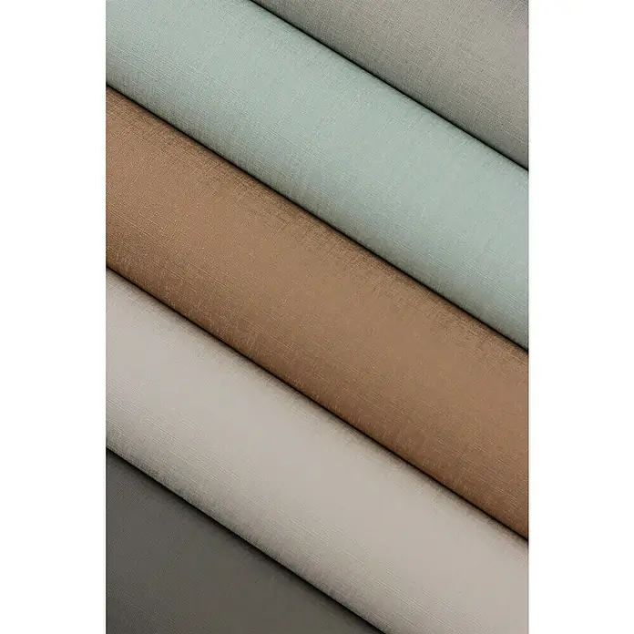 Rasch Tropical House Vliestapete - Hellblau, Uni, 10,05 x 0,53 m - Nahaufnahme von Stoffrollen in verschiedenen Farben und Texturen, die die Vielfalt der verfügbaren Materialien für Designprojekte hervorheben.