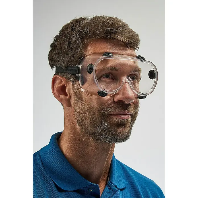 Wisent Gafas de seguridad - Transparente, Con válvula - Un hombre usa gafas de seguridad transparentes con borde negro y una correa elástica oscura para mayor seguridad en el trabajo.