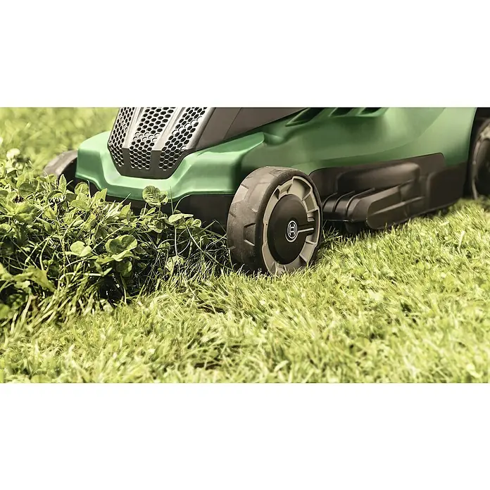 Bosch Elektro-Rasenmäher UniversalRotak 450 - Leistung: 1.300 W, Schnittbreite: 34 cm - Nahaufnahme eines grünen Bosch-Rasenmähers, der über einen Rasen mit Klee fährt.
