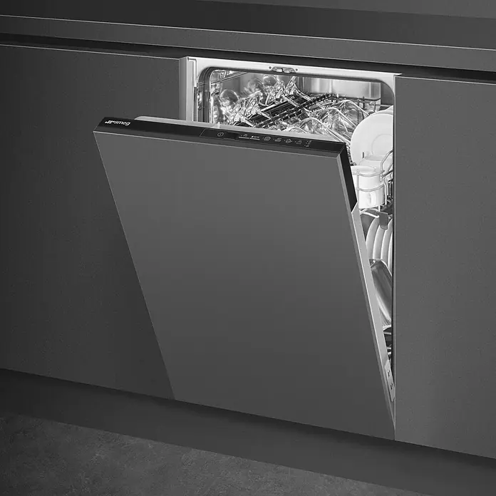 Smeg Lavavajillas integrable ST4512IN - Ancho: 44,6 cm, Número de cubiertos: 9 ud. - Lavavajillas integrable de Smeg, parcialmente abierto y cargado con vajilla. El lavavajillas está integrado en una cocina moderna en gris oscuro.