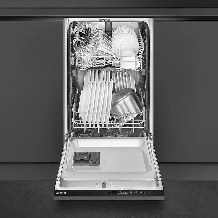 Smeg Lavavajillas integrable ST4512IN - Ancho: 44,6 cm, Número de cubiertos: 9 ud. - Lavavajillas Smeg abierto lleno de platos y cubiertos sobre un fondo oscuro.