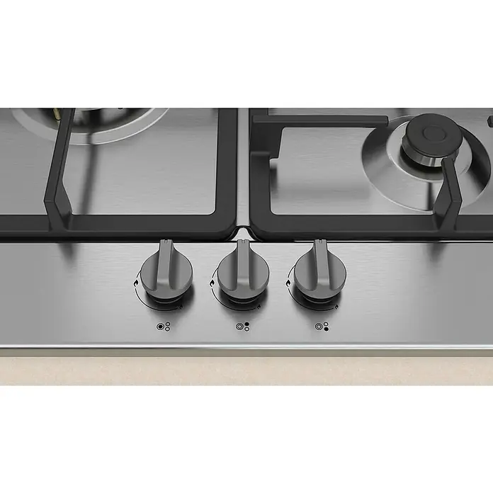 Balay Placa de cocción de gas 3ETX563HB - L x An: 52 x 58,2 cm, Número de quemadores de gas: 3 ud. - Primer plano de una placa de gas plateada con tres mandos de control grises para la regulación del calor.