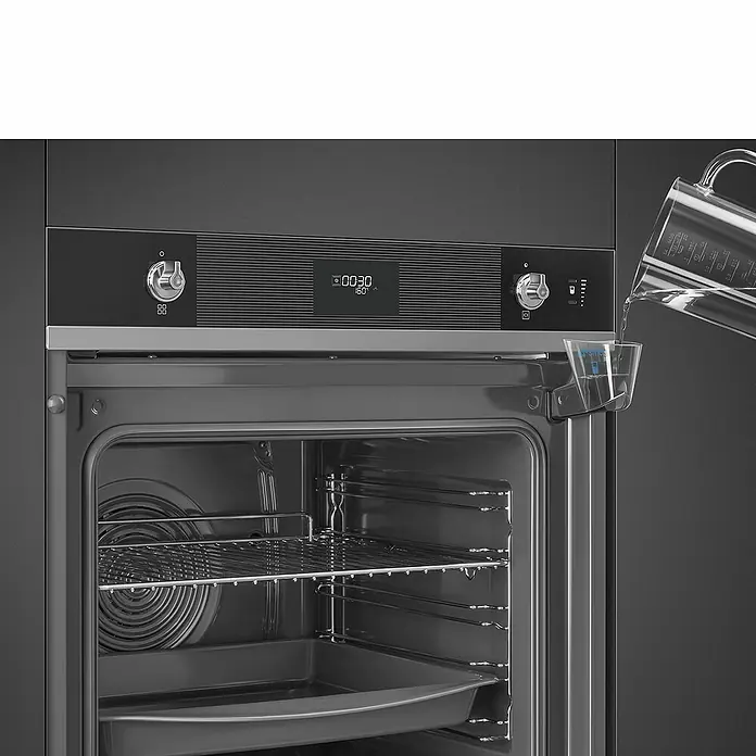 Smeg Horno empotrado SO6101S2N - Número de tipos de calentamiento: 11 ud., Volumen horno: 68 l, Negro - Primer plano de un horno Smeg, mostrando el recipiente de agua para funciones de vapor.
