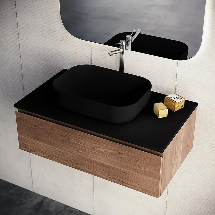 Lavabo y encimera Stadium - 46 x 81 cm, Negro - Lavabo sobre encimera negro sobre mueble de madera con encimera negra, reflejado en el espejo.