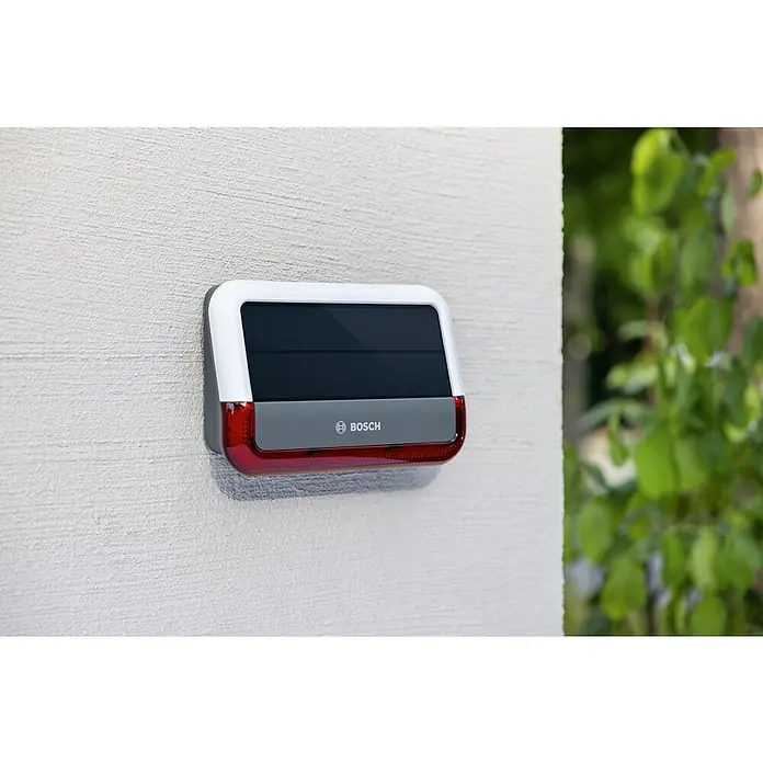 Bosch Smart Home Außensirene - 100 dB - Bosch Alarmsirene mit Solarpanel für den Außenbereich. Die Alarmsirene ist weiß und rot mit dem Bosch-Logo auf der Vorderseite.