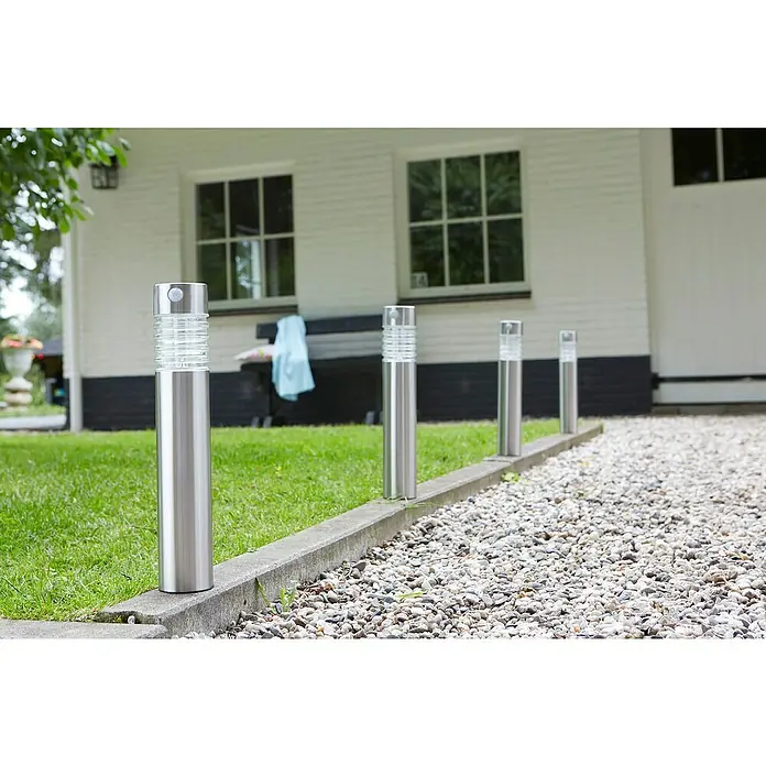 Luxform Solar Intelligent Hybrid Solar-Sockelleuchte Arizona - L x B x H: 7,6 x 7,6 x 56 cm, Silber, IP44 - Außenansicht einer Reihe von Edelstahl-Gartenleuchten mit geriffeltem Glas, die einen Weg säumen. Sie bieten effektive Beleuchtung für jeden Gartenweg.