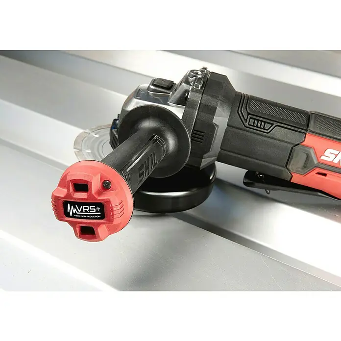 Skil Elektro-Winkelschleifer 9132 AB - 850 W, Durchmesser Scheibe: 125 mm, Leerlaufdrehzahl: 12.000 U/min - SKIL Winkelschleifer mit rotem Griff und VRS+ Vibrationsreduktion auf einer Metalloberfläche. Präzision und Komfort vereint.
